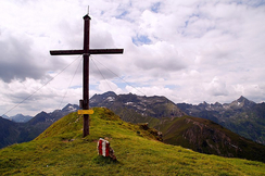 Gipfelkreuze wie dieses durch Windräder zu ersetzen würde die Zerstörung der einzigartigen Berglandschaft durch Straßenbauten und Waldrodungen bedeuten.